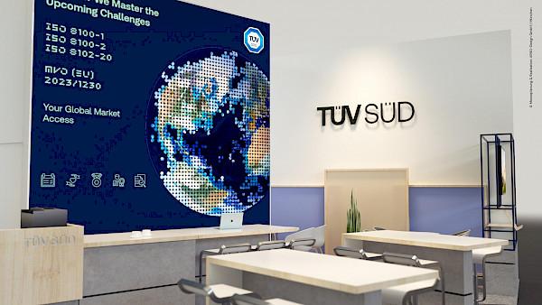 Nahaufnahme einer dunkelblauen Messewand mit einer zentralen Erdkugel-Grafik, die aus runden Pixeln besteht. Das Design beinhaltet Typografie zu ISO-Normen in einer digitalen Pixel-Schriftart sowie das TÜV SÜD Logo – ein modernes Grafik-Konzept für technisches Branding.